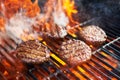Cooking burgers on hot grill with flames Royalty Free Stock Photo