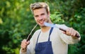 Cooking burgers. Man hold barbeque equipment. Grilling food. Barbecue utensils. Summer weekend. Tools for roasting meat Royalty Free Stock Photo