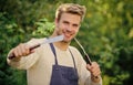 Cooking burgers. Man hold barbeque equipment. Grilling food. Barbecue utensils. Summer weekend. Tools for roasting meat Royalty Free Stock Photo