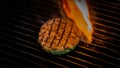 Cooking burgers patty on hot grill with flames. Burger preparation Royalty Free Stock Photo