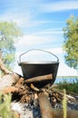 Cooking camping food. Camping cauldron standing on a campfire in the nature outdoors. Vertical photo