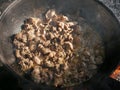 Cooking in a cauldron on open air on a summer day. Roasting meat in kazan over a fire. Traditionally a way of cooking.