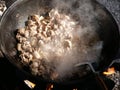 Cooking in a cauldron on open air on a summer day. Roasting meat in kazan over a fire. Traditionally a way of cooking.