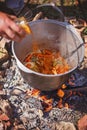 Cooking outdoors in cast iron cauldron Royalty Free Stock Photo