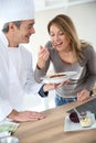 Cooking chef preparing pasta for woman