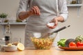 Cooking. Chef salt salad, in the process of vegetarian salad in the home kitchen. Light background. Restaurant menu, menu, recipe