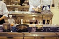 Cooking by chefs in a large kitchen with lots of stoves, pans and equipment