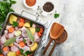 Cooking chicken bouillon or roast in cooking pan or pot with vegetables potatoes, carrots and herbs on kitchen grey concrete Royalty Free Stock Photo