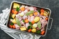 Cooking chicken bouillon or roast in cooking pan or pot with vegetables potatoes, carrots and herbs on kitchen grey concrete Royalty Free Stock Photo