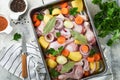 Cooking chicken bouillon or roast in cooking pan or pot with vegetables potatoes, carrots and herbs on kitchen grey concrete