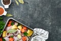 Cooking chicken bouillon or roast in cooking pan or pot with vegetables potatoes, carrots and herbs on kitchen grey concrete Royalty Free Stock Photo