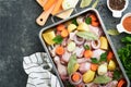 Cooking chicken bouillon or roast in cooking pan or pot with vegetables potatoes, carrots and herbs on kitchen grey concrete Royalty Free Stock Photo