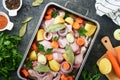 Cooking chicken bouillon or roast in cooking pan or pot with vegetables potatoes, carrots and herbs on kitchen grey concrete Royalty Free Stock Photo