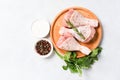 Cooking chicken drumsticks with seasonings and spices on wooden plate over white table background Royalty Free Stock Photo