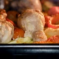 Cooking chicken with vegetables in the oven. Chicken legs and thighs with marinade, potatoes, tomatoes and paprika Royalty Free Stock Photo