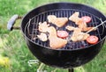 Cooking of chicken wings, mushrooms and tomatoes on barbecue grill outdoors Royalty Free Stock Photo