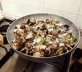Cooking clams in a stone pan using parsley and white wine