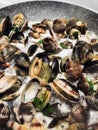 Cooking clams in a stone pan using parsley and white wine Royalty Free Stock Photo