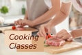 Cooking classes. Blurred view of woman preparing meat on wooden board at table Royalty Free Stock Photo