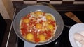 Cooking the classic Israeli food shakshuka from tomatoes and eggs