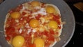 Cooking the classic Israeli food shakshuka from tomatoes and eggs