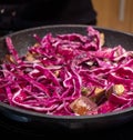 Cooking a colourful vegan Asian Pad Thai stir fry with red cabbage, tofu, aubergine and noodles with wooden spoons in a frying pan Royalty Free Stock Photo