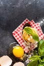 Cooking concept. Ingredients for traditional Italian homemade pasta tomatoes  raw egg  basil leaf on the dark concrete background Royalty Free Stock Photo