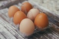 Set of six fresh brown eggs on clear plastic box. Wooden table background. Royalty Free Stock Photo