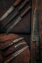 Cooking concept picture of collection of rustic knives on wooden chopping board Royalty Free Stock Photo