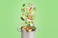 Fresh vegetables flying into pot, isolated on green background Royalty Free Stock Photo