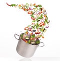 Fresh vegetables flying into pot, isolated on white background Royalty Free Stock Photo