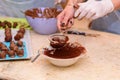 Young woman making chocolate candies.