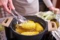 Cooking corn cob in a pot of boiling water with bubbles Royalty Free Stock Photo