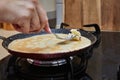 Cooking Crepe Suzette pancakes in frying pan on gas stove