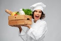 Happy smiling female chef with food in wooden box Royalty Free Stock Photo