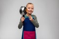 little girl in apron playing with pot and spoon Royalty Free Stock Photo