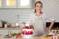 Cooking and decoration of cake with cream. Young woman pastry chef in the kitchen decorating red velvet cake Royalty Free Stock Photo