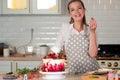 Cooking and decoration of cake with cream. Young woman pastry chef in the kitchen decorating red velvet cake. Royalty Free Stock Photo