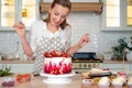 Cooking and decoration of cake with cream. Young woman pastry chef in the kitchen decorating red velvet cake.