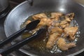 Cooking deep fried chicken on a steel wok at the kitchen. Frying with vegetable oil. Closeup shot