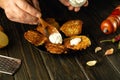 Cooking a delicious dish of potato pancakes and sour cream. Spoon in the hand of the cook at the time of serving Royalty Free Stock Photo