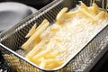 Cooking delicious french fries in hot oil, closeup Royalty Free Stock Photo