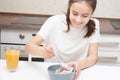 Cooking a delicious and healthy breakfast. Young woman in the kitchen preparing muesli with fresh fruits and yogurt Royalty Free Stock Photo