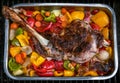 Cooking a delicious leg of lamb on a BBQ with peppers and potatoes in metal tray Royalty Free Stock Photo