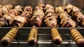 Cooking delicious meat skewers on skewers with wooden handles. Street eatery. Grilled food. Automatic rotation of skewers. B-B-Q. Royalty Free Stock Photo