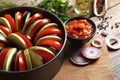 Cooking delicious ratatouille. Different fresh vegetables and round baking pan on wooden board, closeup Royalty Free Stock Photo