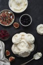 Cooking dessert. Abstract food background. Top view of mini Pavlova meringue cakes decorated with berries and figs