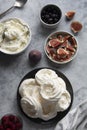 Cooking dessert. Abstract food background. Top view of mini Pavlova meringue cakes decorated with berries and figs