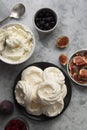 Cooking dessert. Abstract food background. Top view of mini Pavlova meringue cakes decorated with berries and figs