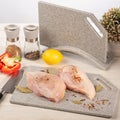 Cooking a dish of chicken meat on a cutting kitchen board made of artificial stone Royalty Free Stock Photo
